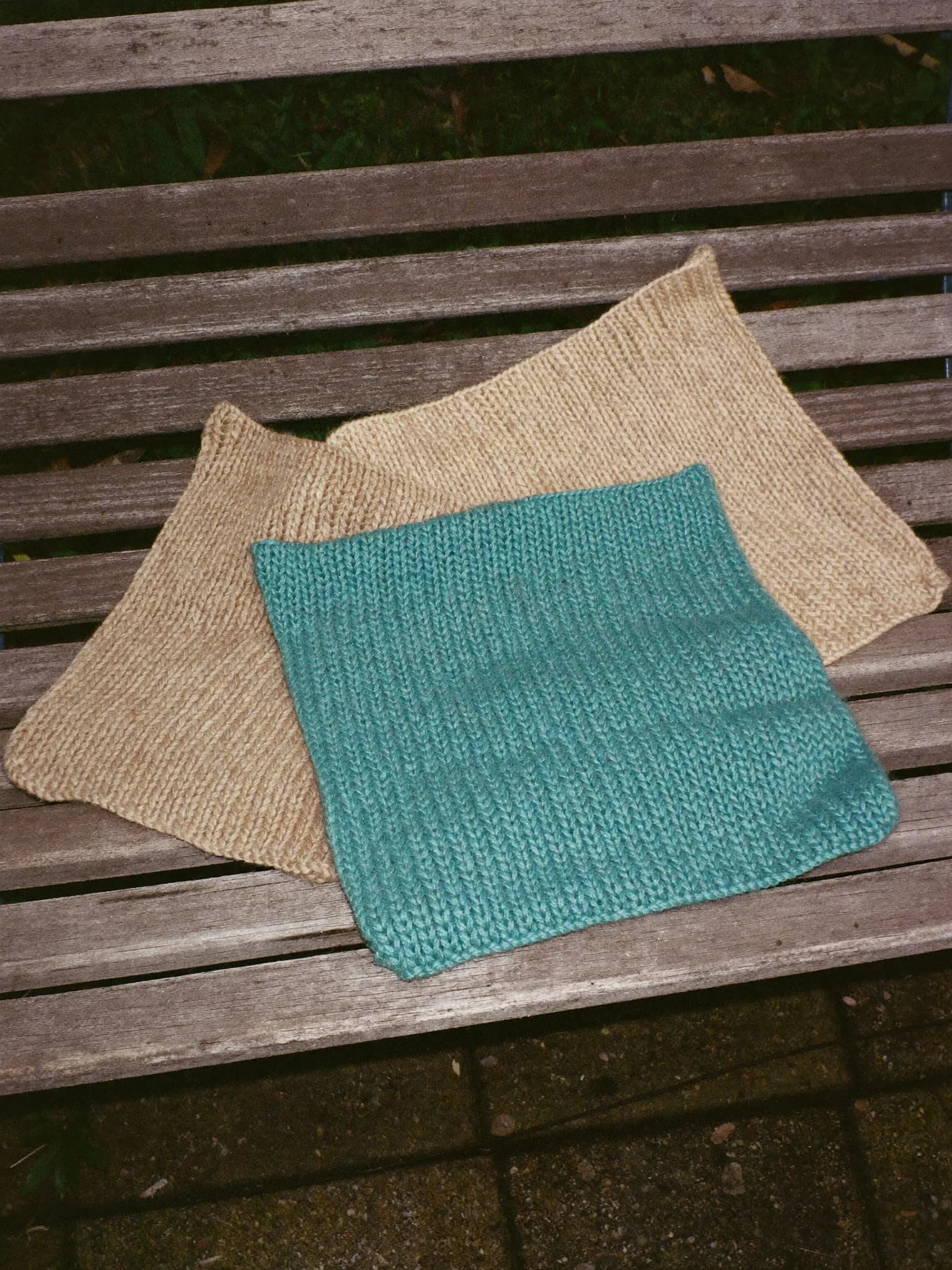 Knit Dish Cloths, set of 3 in Bone, Sand, Teal, folded on a wooden garden bench