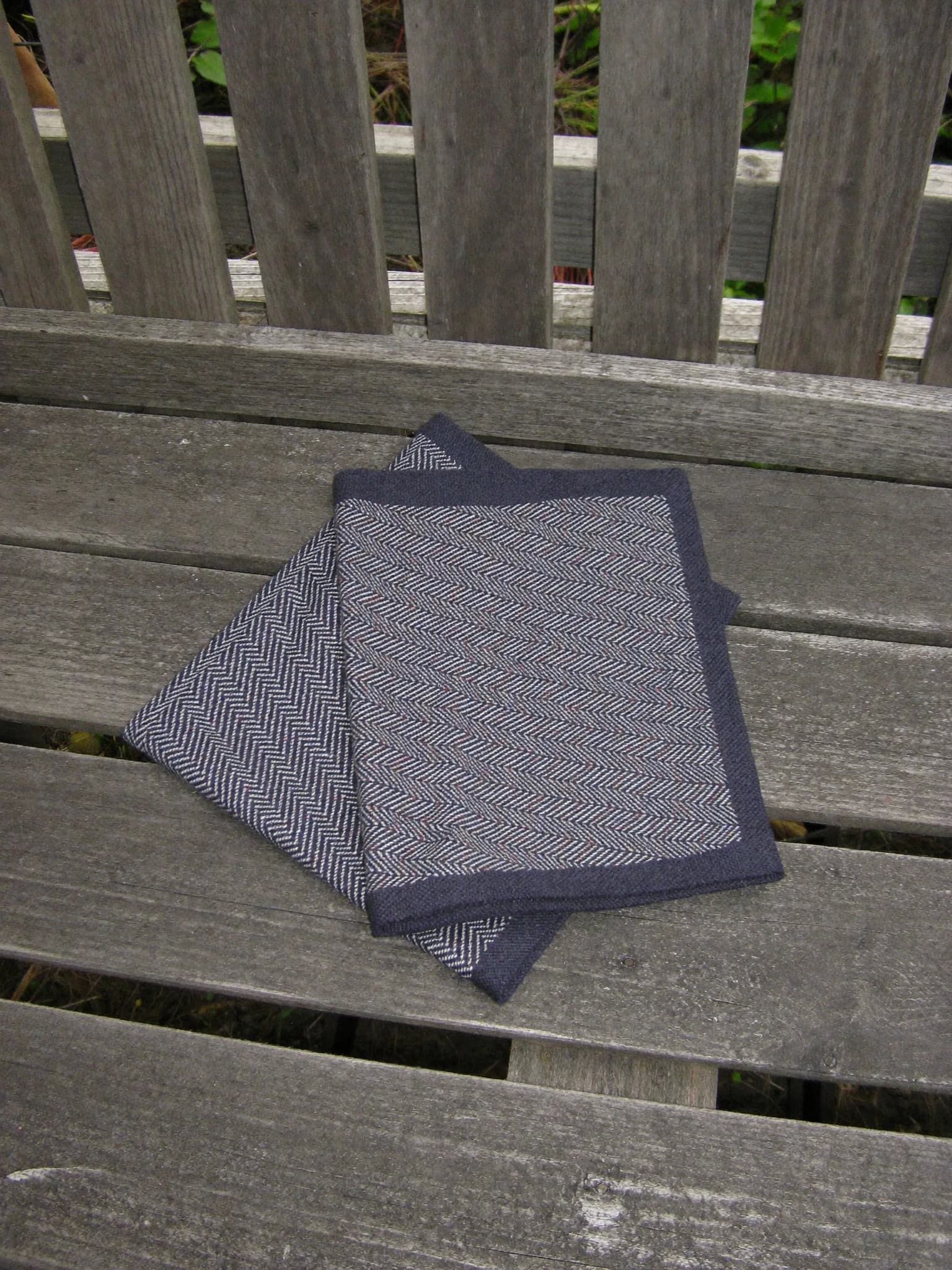 Herringbone Towel in Ink, folded on a wooden garden bench